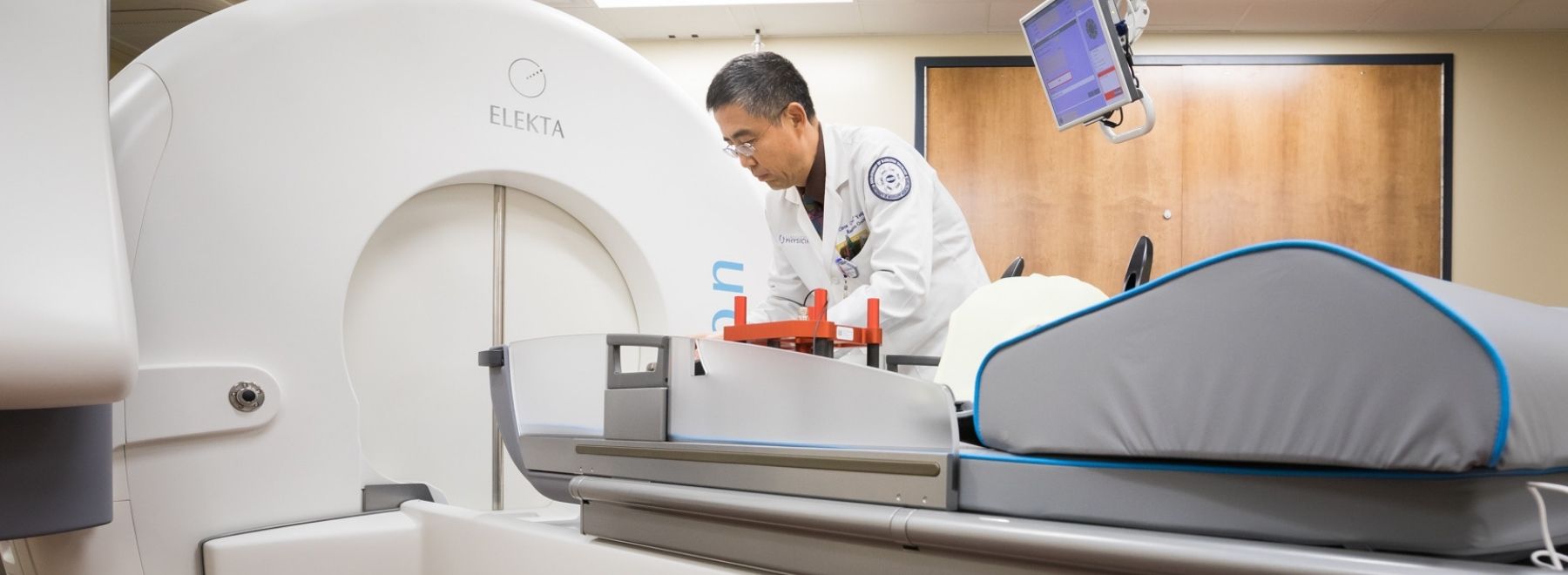 A physician examines aspects of Gamma Knife (R) radiosurgery equipment.
